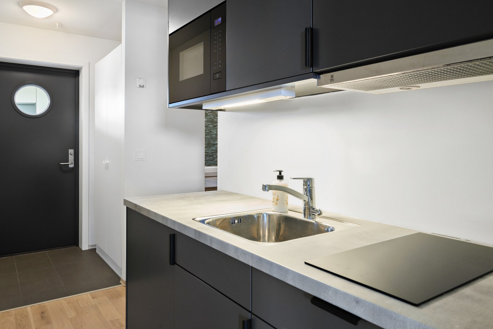 Enkelt hybelkjøkken med åpen løsning mot hybel/oppholdsrom Galleribilde