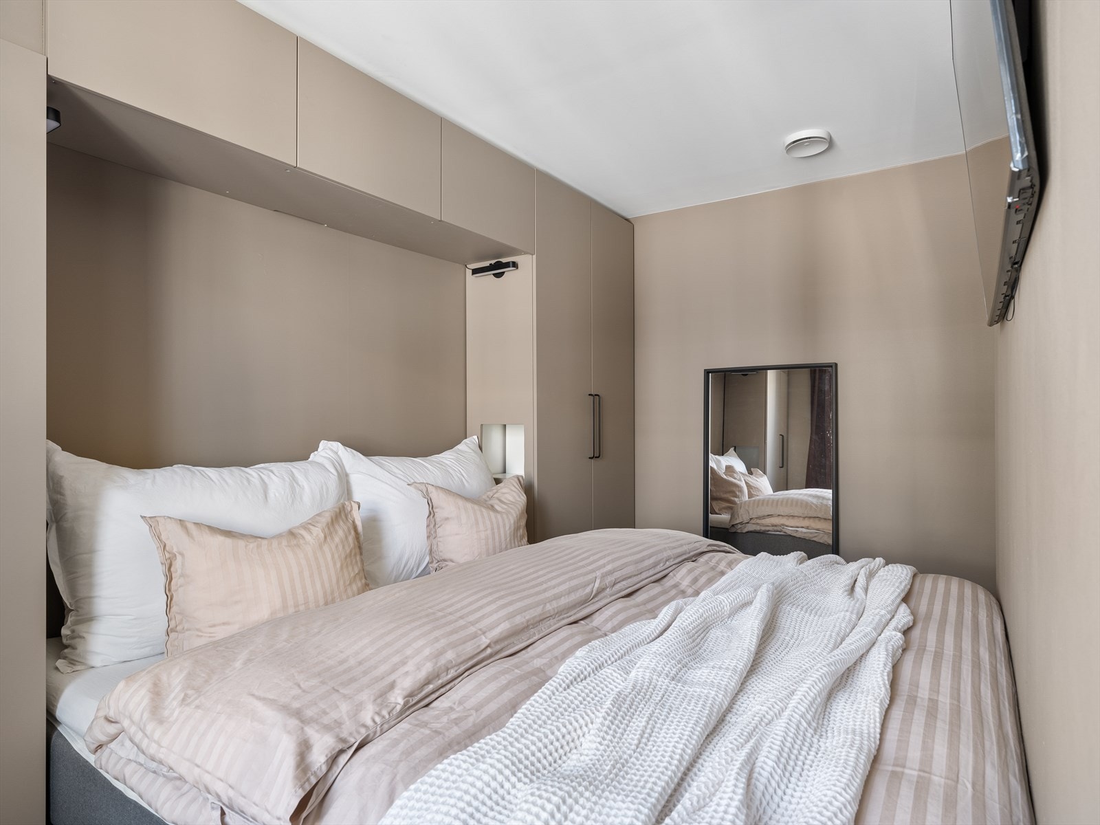 Skapplass på hver side, samt over seng - gir gjennomgående god kapasitet i 1 soveroms kategorien. Soverom og garderobe er malt med muskatnøtt. Galleribilde