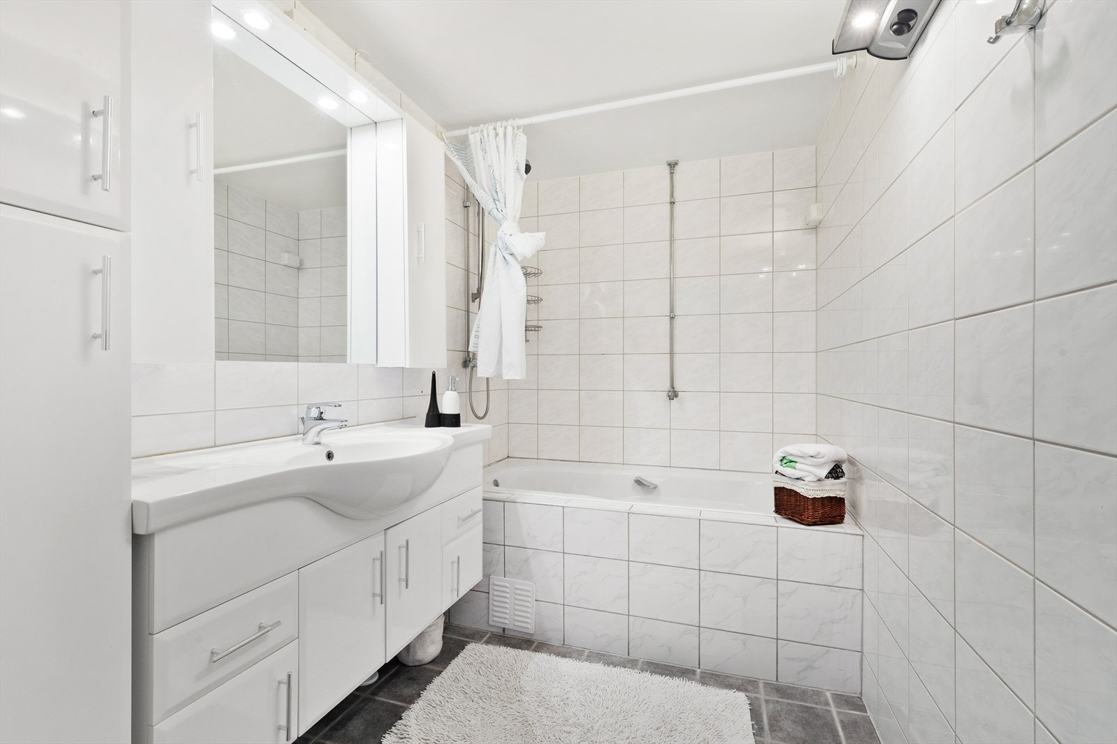 Lyst og romslig bad med dusj i badekar og rikelig med oppbevaringsplass. Galleribilde