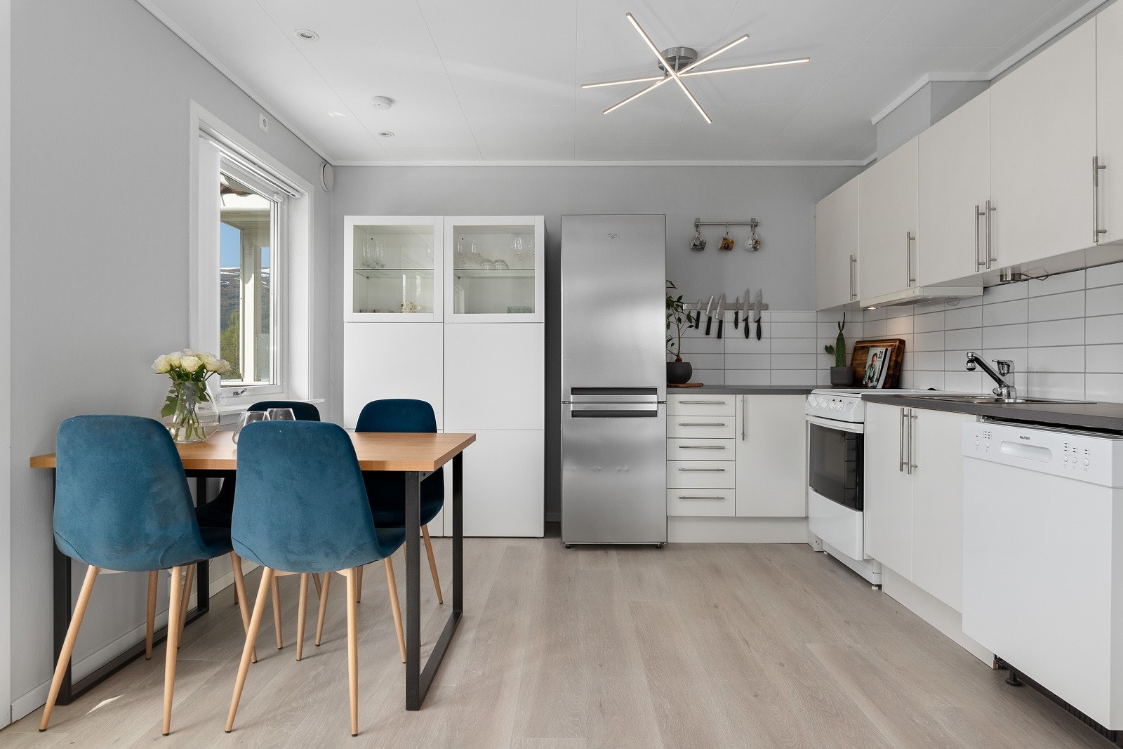 Flott Norema-kjøkken med hvite, glatte fronter og benkeplate av laminat. Galleribilde