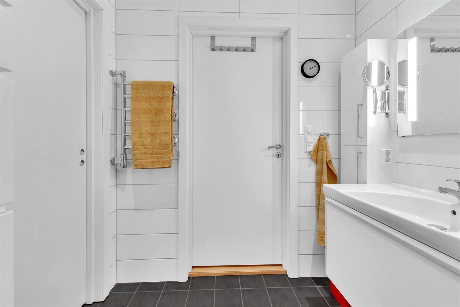 Badet er blant annet innredet med baderomsinnredning med servant, dusjhjørne med glassdører, wc, oppbevaringsskap og opplegg for vaskemaskin. Galleribilde