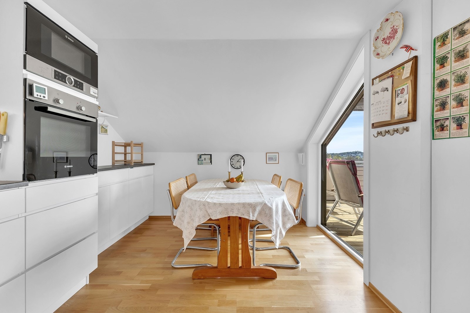 Det er plass til frokostbord på kjøkkenet. Stort vindu mot terrassen. Galleribilde