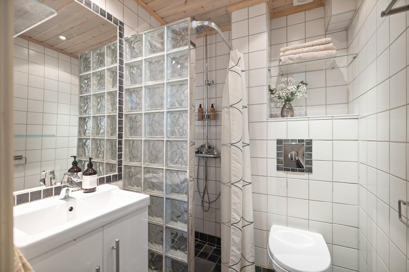 Flislagt bad med varmekabler i gulv og downlights i himling. Galleribilde