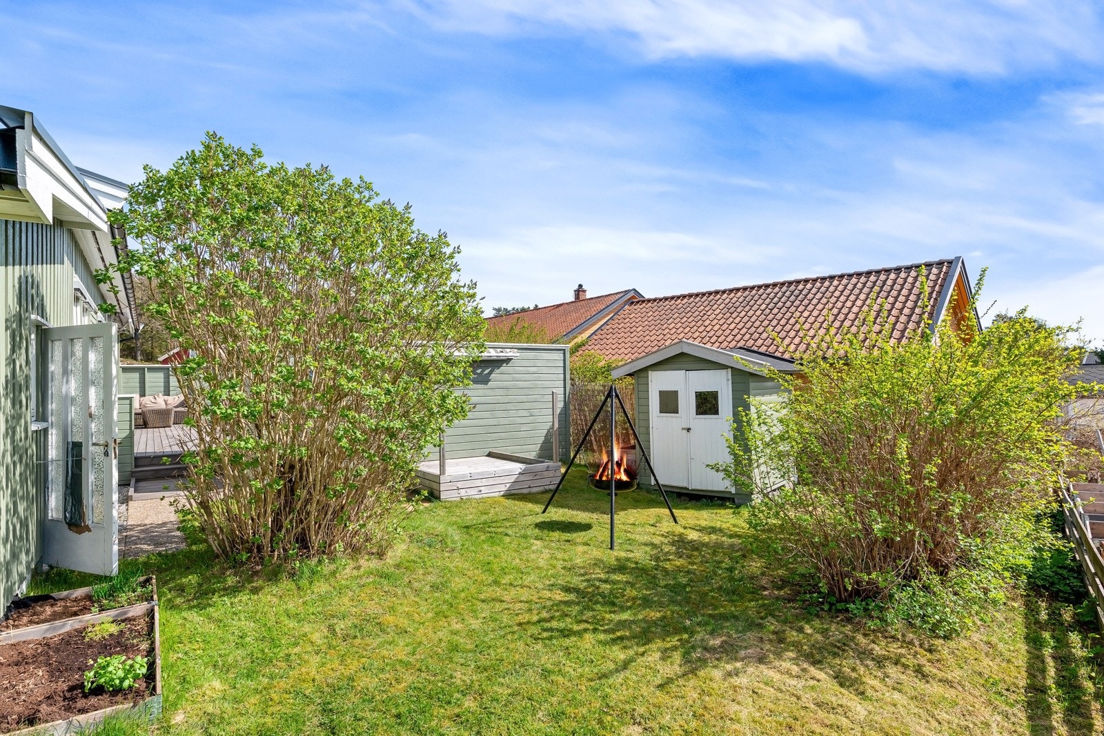 Tomten er opparbeidet med gressplen, busker, bed og hekker. Galleribilde