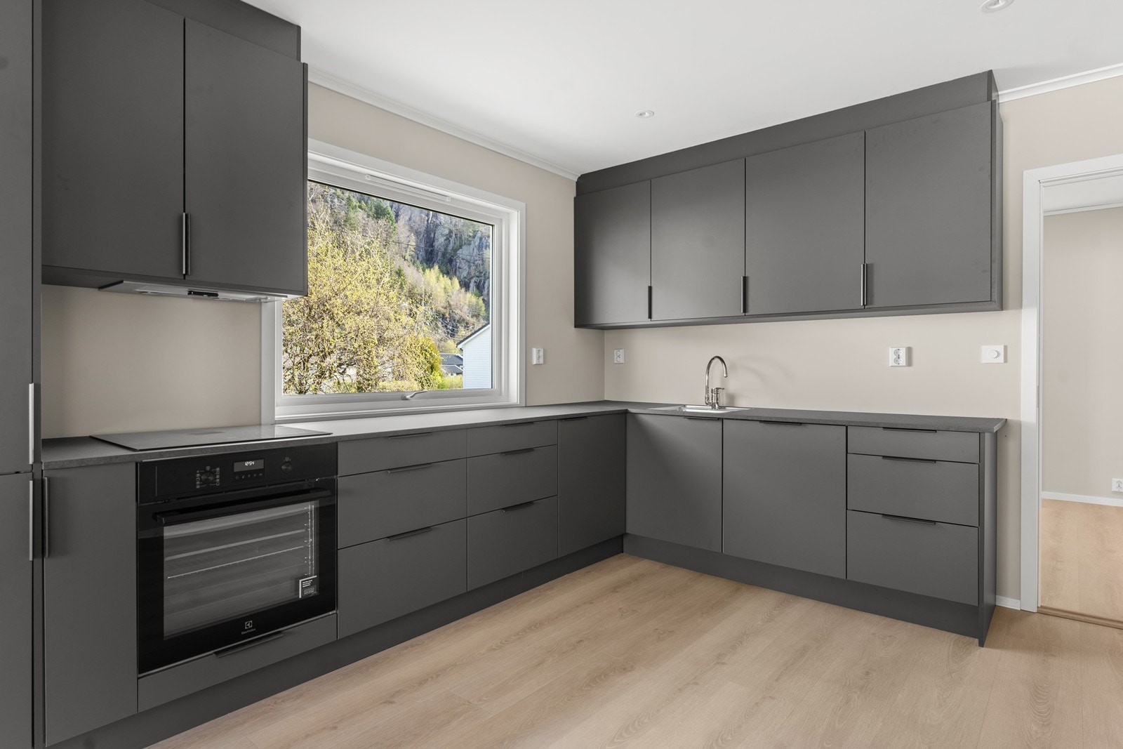 Stilig nytt kjøkken med grå matte fronter og integrerte hvitevarer. Galleribilde