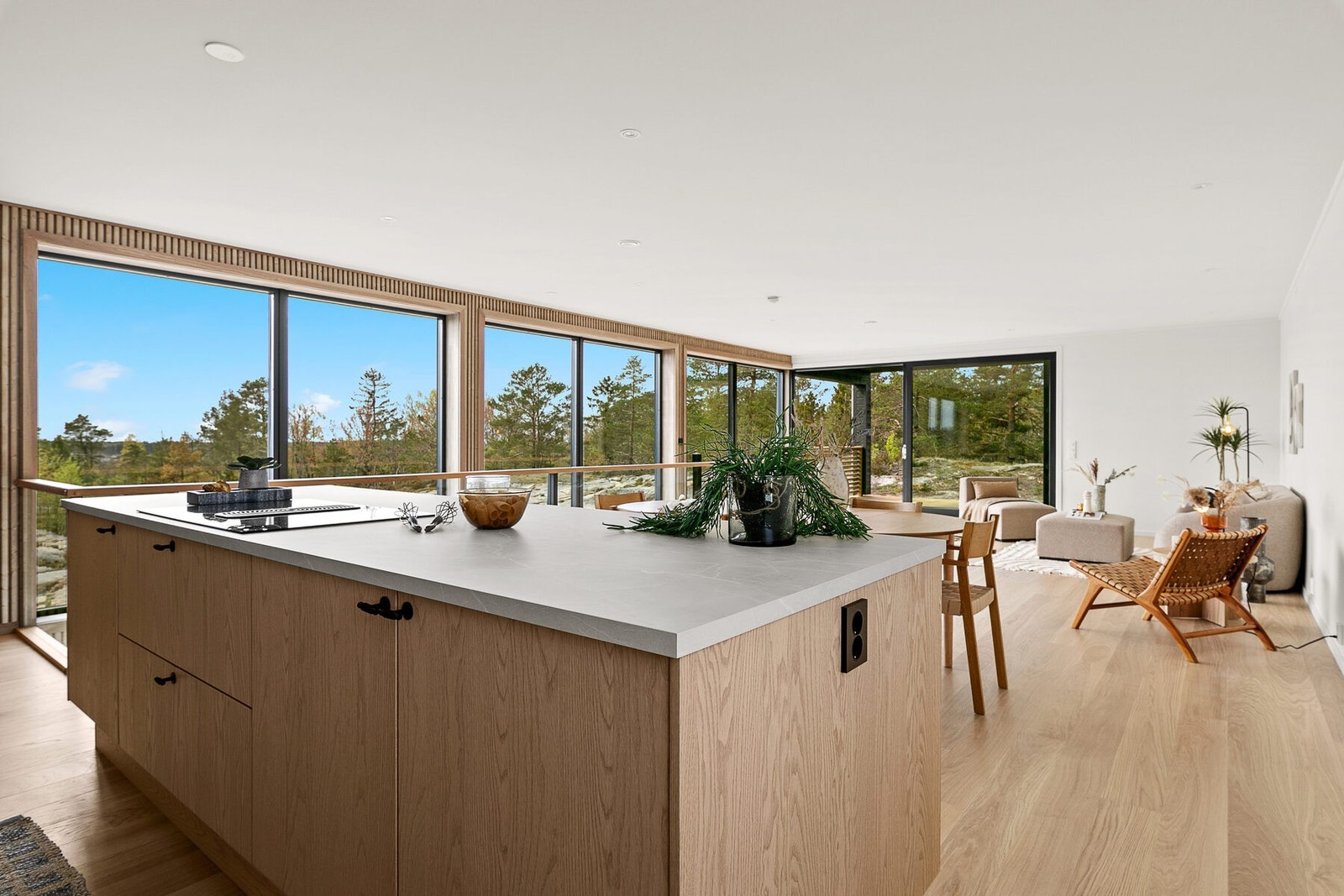 Stor kjøkkenøy avgrenser kjøkkenet mot spiseplassen og stua Galleribilde