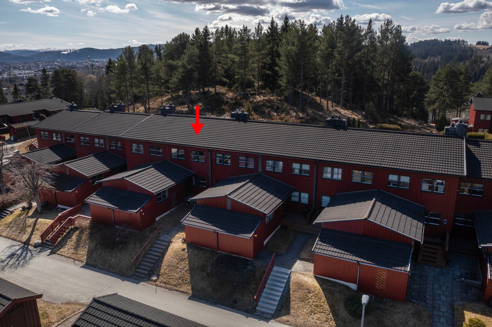 Fremside inngangsside. Romslig bod utenfor inngangsparti. Rød pil markerer boligens plassering. Galleribilde