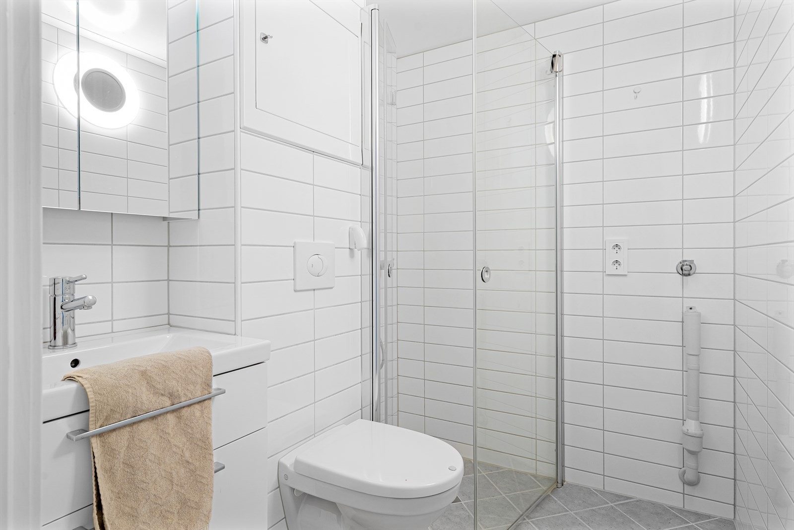 Badet er av god størrelse og er innredet med dusj, wc og lekker servant med tilhørende skuffer Galleribilde