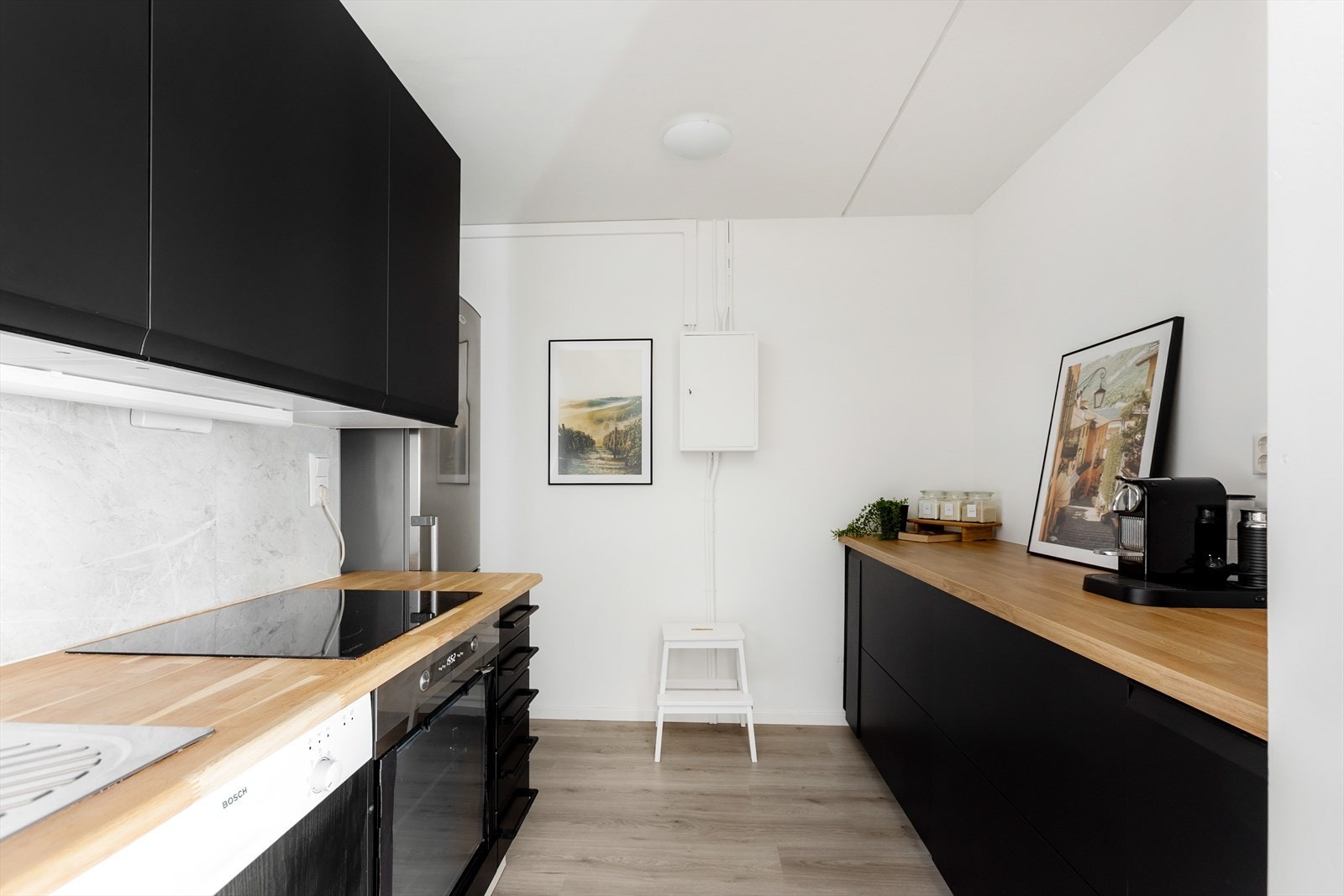 Kjøkkeninnredningen består av glatte fronter, med heltre og laminat benkeplate samt nedfelt kum i rustfritt stål. Galleribilde