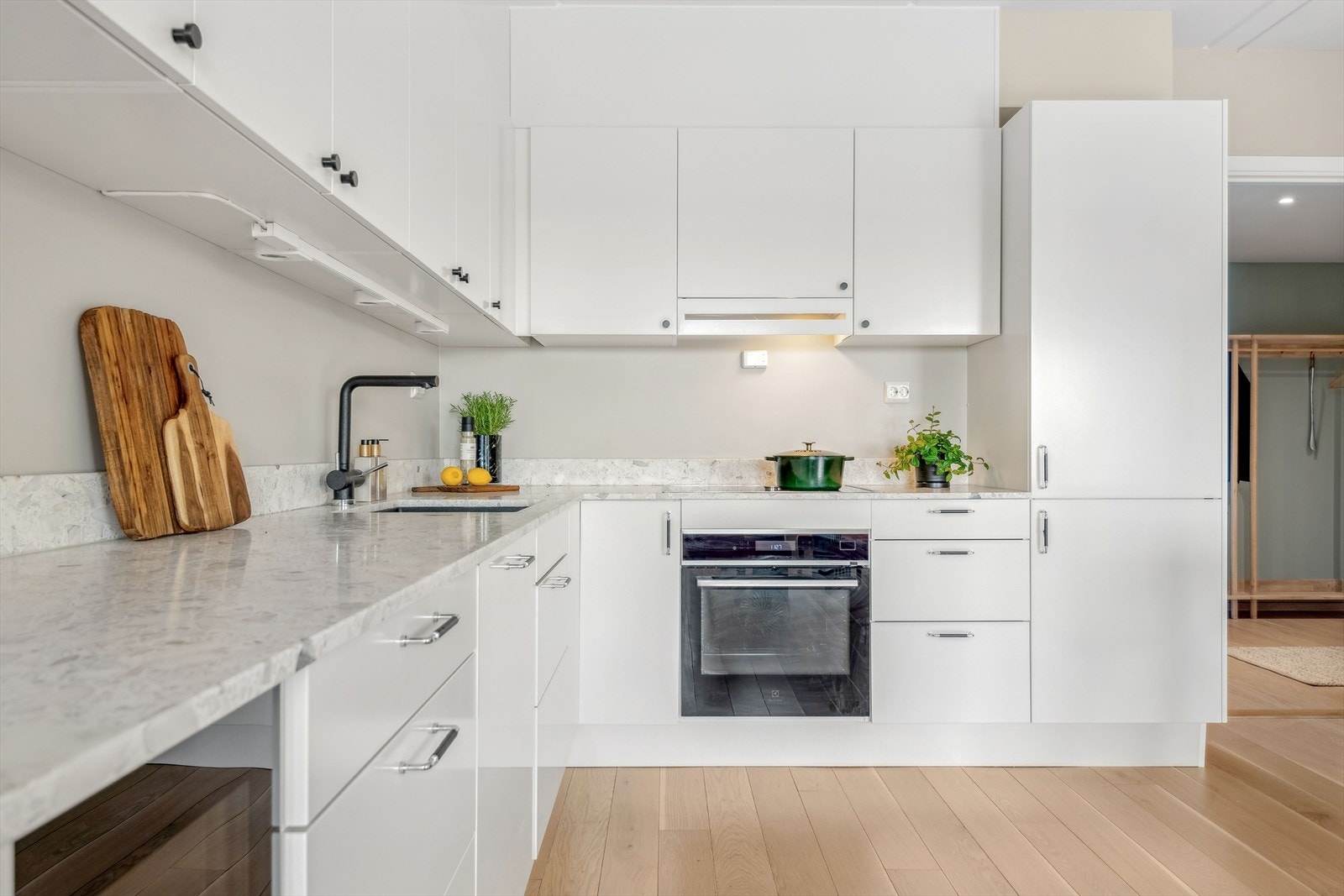 Kvalitetssikre hvitevarer med integrert induksjon platetopp og ovn fra Gaggenau og oppvaskmaskin, vinskap og kjøleskap med fryser fra AEG. Det er montert lys under overskap og kjøkkenavtrekk i skap over platetopp. Galleribilde