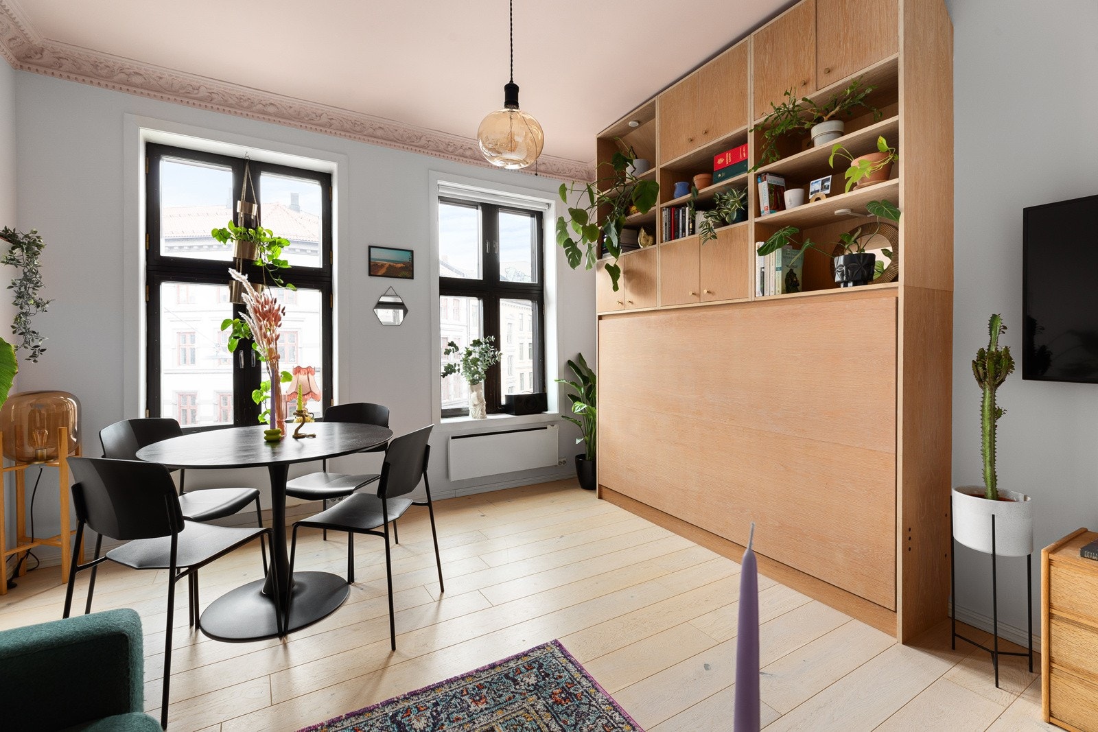 Arkitekttegnet sengeløsning i stuen som sørger for at man har god plass til spisebord og sofa Galleribilde
