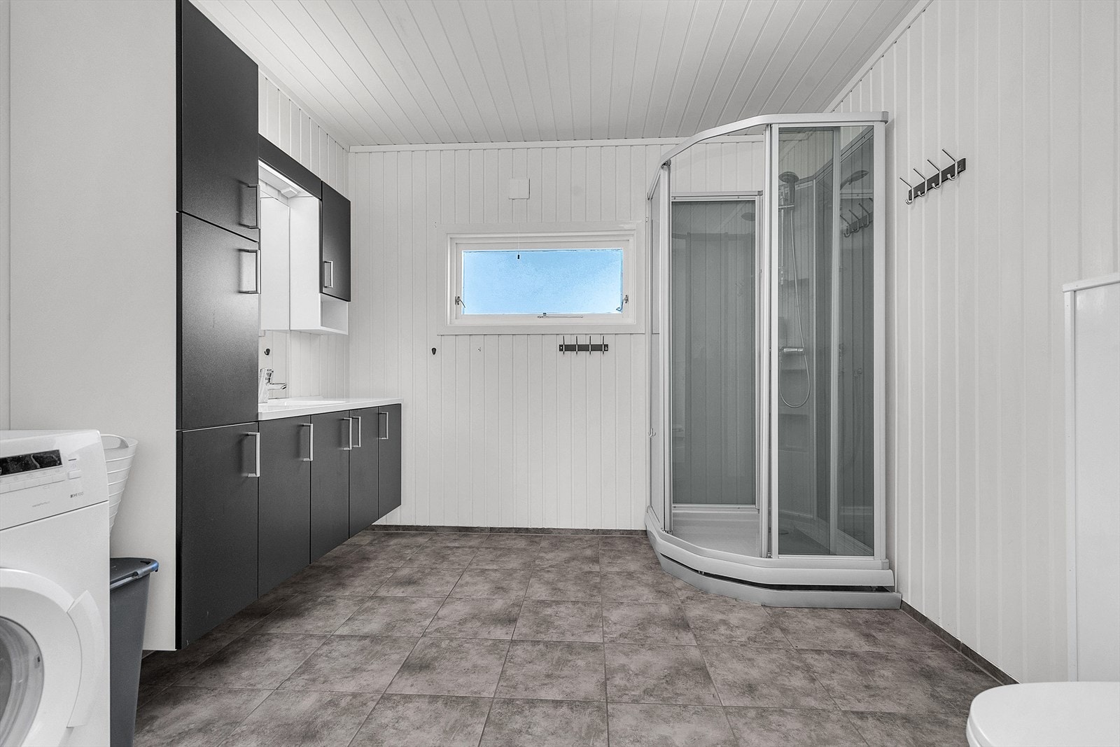 Romslig bad med dusjkabinett og opplegg for vaskemaskin Galleribilde