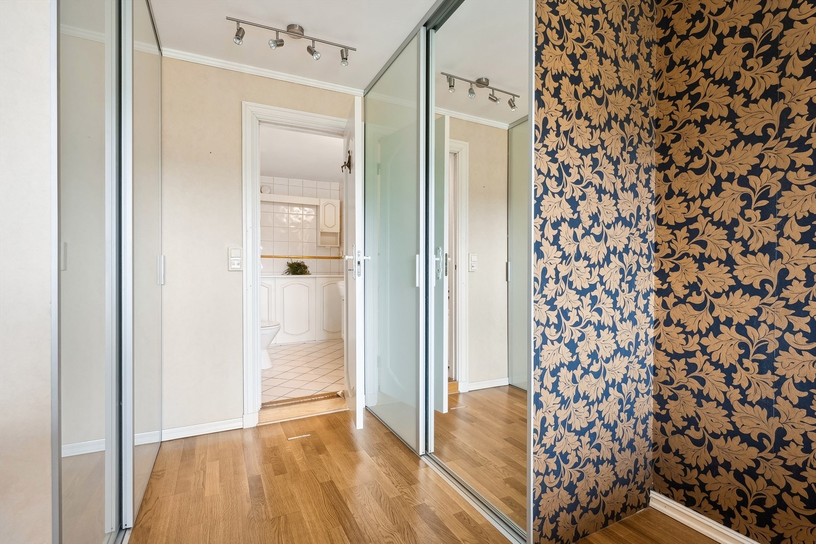 Den ene soverommet har god plass til dobbeltseng, nattbord og kommode i tillegg til to innebygde skyvedørsgarderober Galleribilde