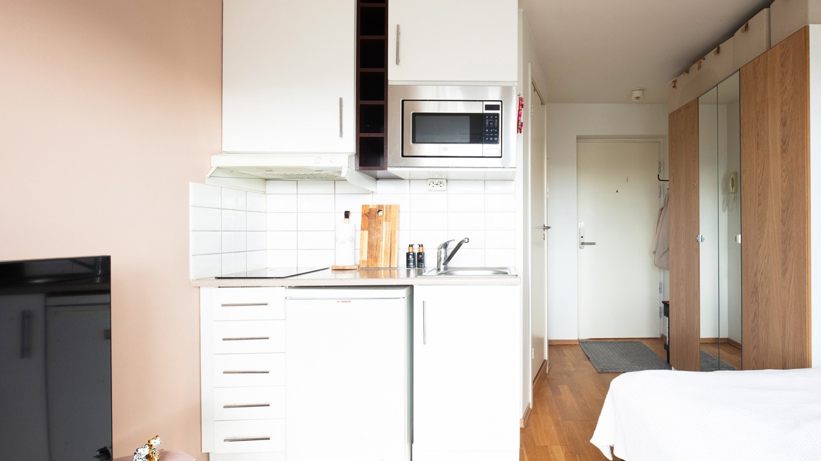 Åpen stue/kjøkkenløsning med kjøkkeninnredning i lyst, tidløst design. Integrert platetopp og micro. Galleribilde