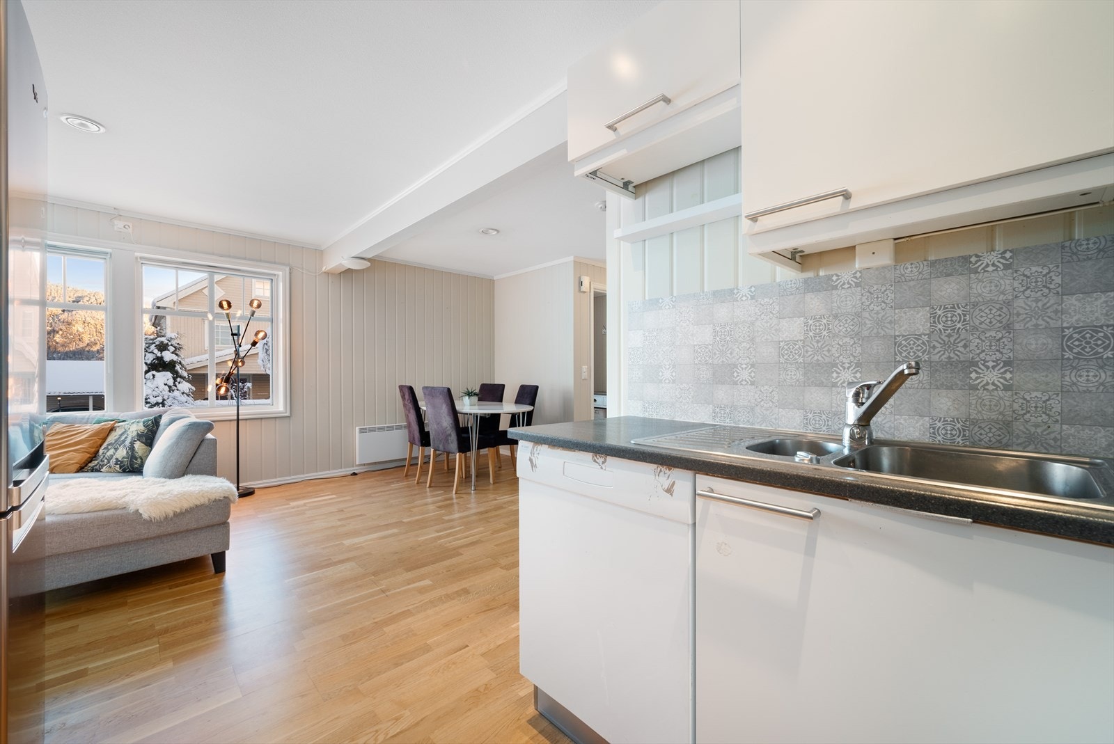 Stue/kjøkken har 3-stavs parkettgulv fra 2016, mens veggene er kledd med lysmalte panelplater. Galleribilde