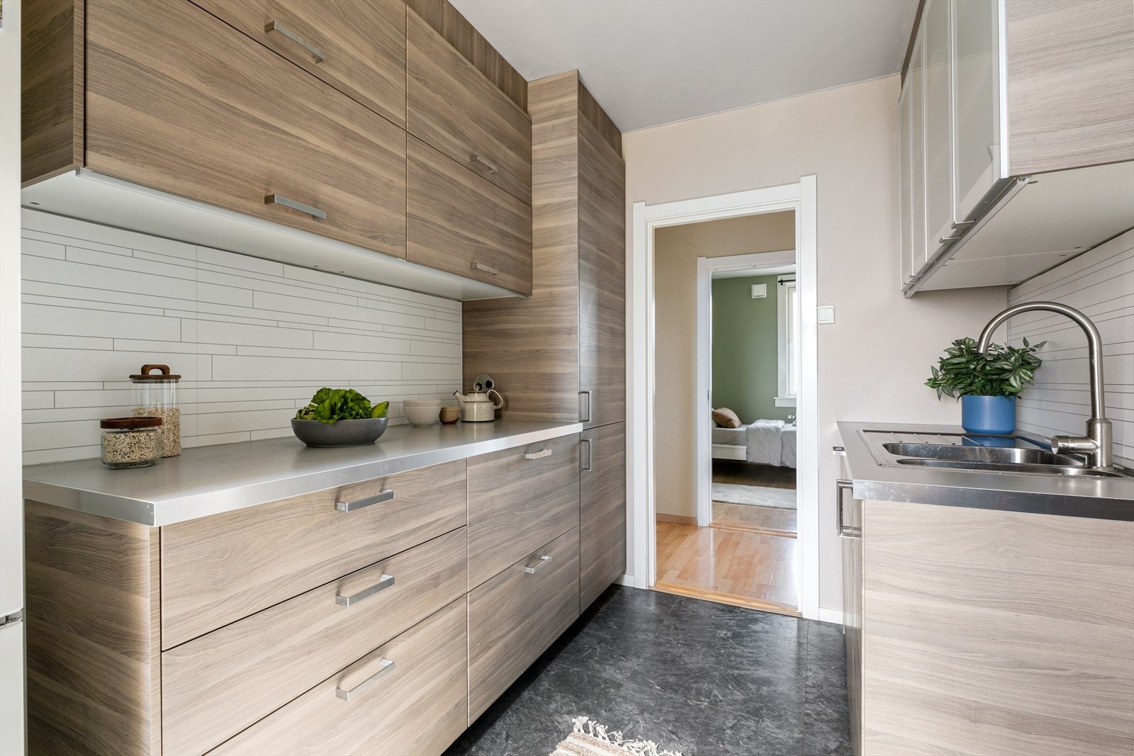 Mørkt og moderne kjøkken. Kjøkkeninnredning med glatte fronter og glass i enkelte overskap med laminat benkeplater. Galleribilde