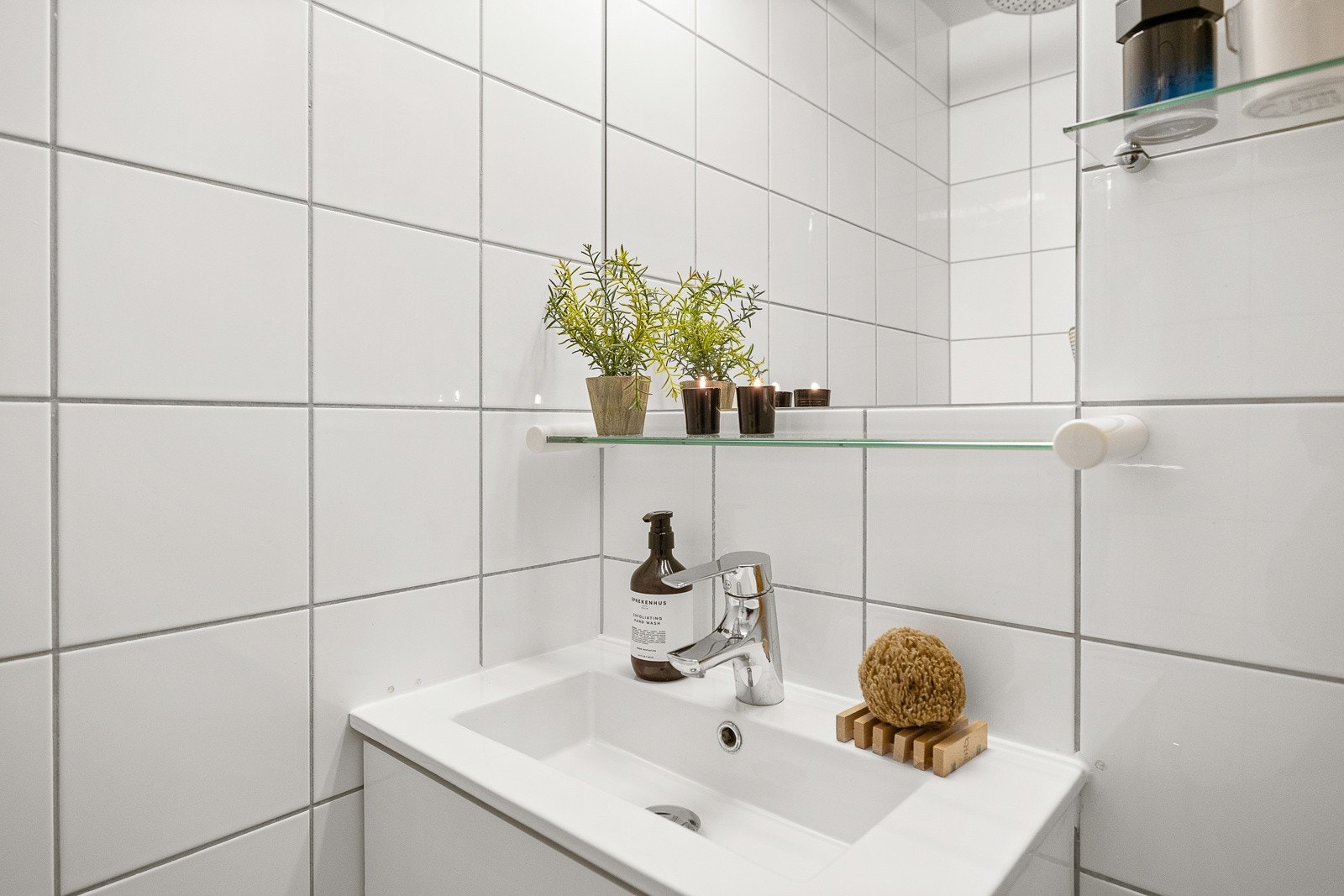 Badet er innredet med skap med servant, speil, dusj og vegghengt toalett. Galleribilde