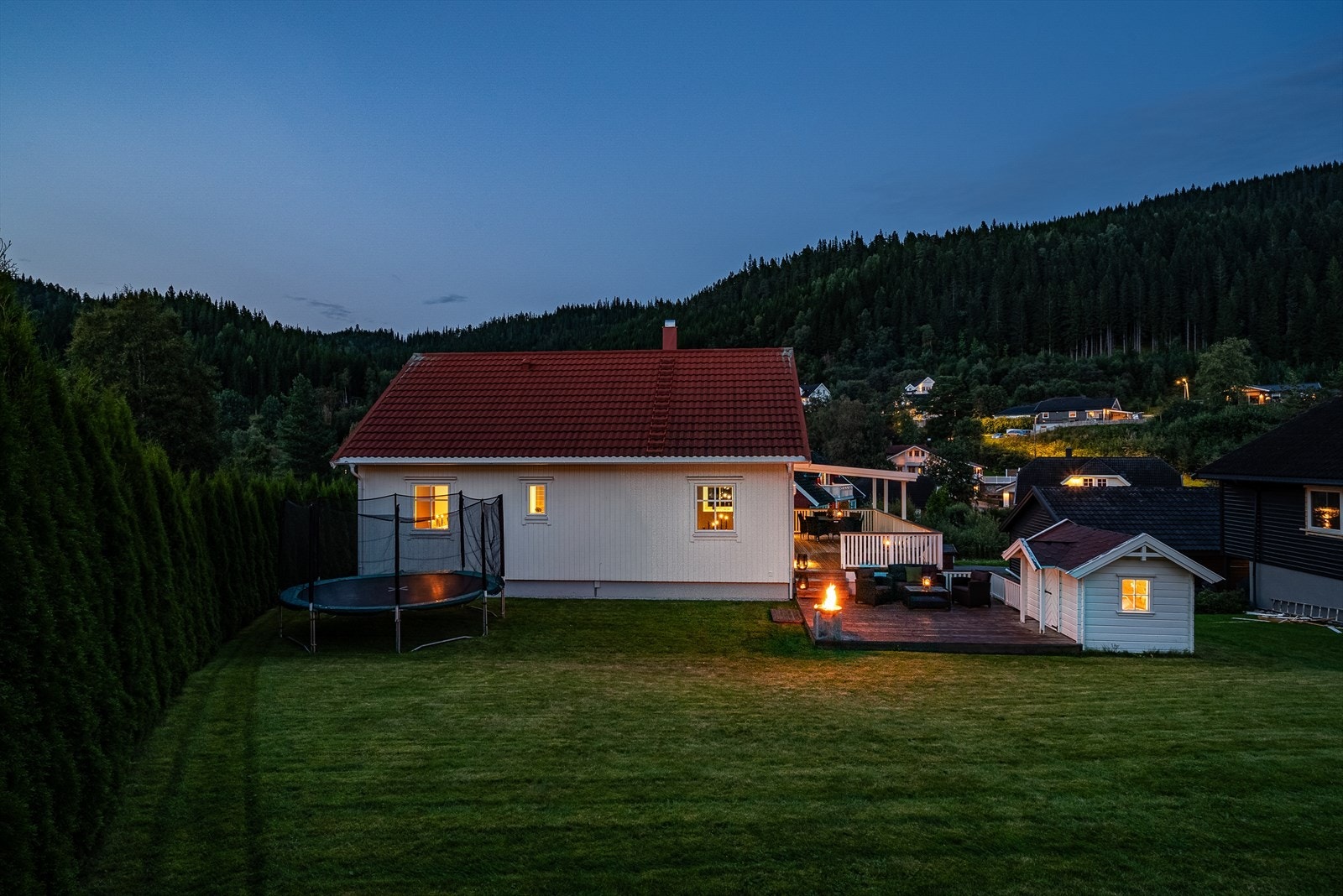 Hagen er godt skjermet mot veien av høy tujahekk. Her er det plass til lek, ballspill og trampoline med mer. Galleribilde