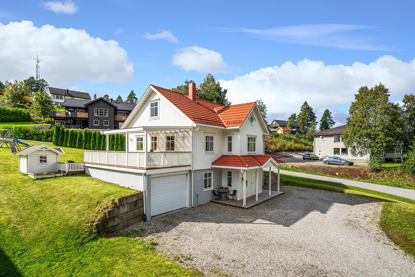 Gårdsplassen byr på godt med parkeringsmuligheter, i tillegg til den integrerte garasjen som har leddport med fjernåpner. Galleribilde