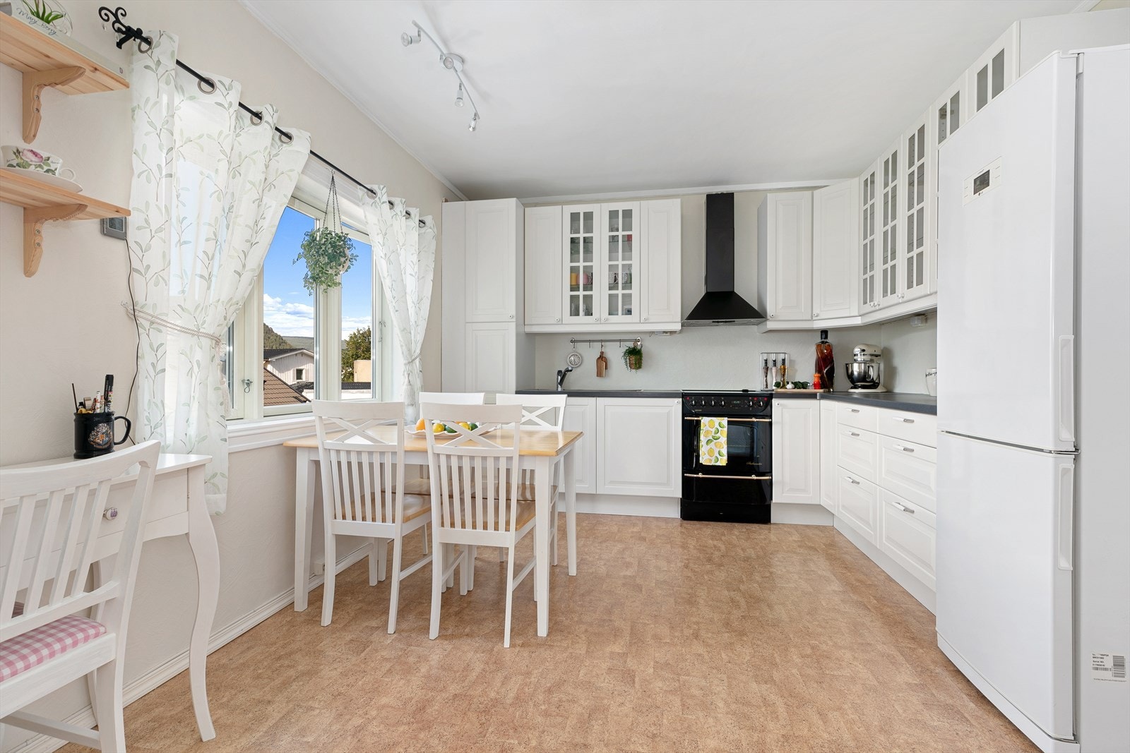 Romslig kjøkken som er godt utnyttet med god benk- og skapplass, samt mulighet for trivelig spiseplass ved kjøkkenvinduet. Galleribilde