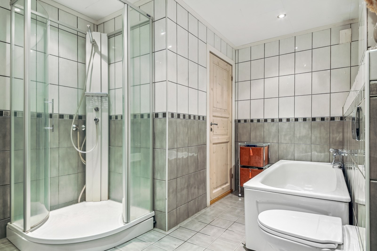Badet inneholder nedfelt servant i skuffeseksjon, toalett, dusjkabinett og badekar Galleribilde