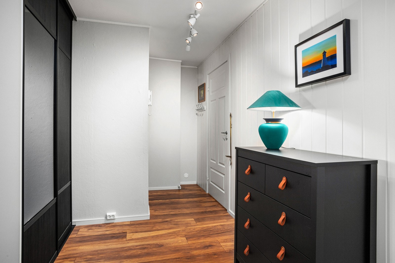 Velkommen inn! Stor og praktisk gang som er lys og ryddig med laminatgulv med varmematte og hvitmalte vegger. Galleribilde