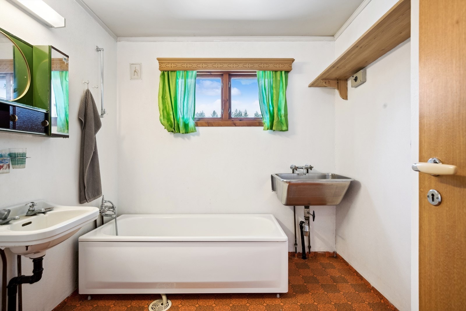 Eldre bad som er innredet med toalett, servant, badekar og utslagsvask. Galleribilde