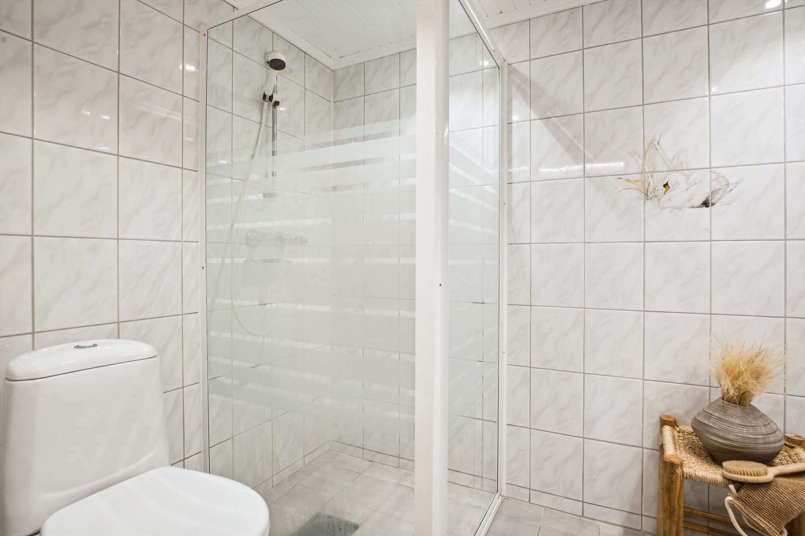 På badet er det toalett, downlights og et dusjhjørne med glassvegger. Galleribilde