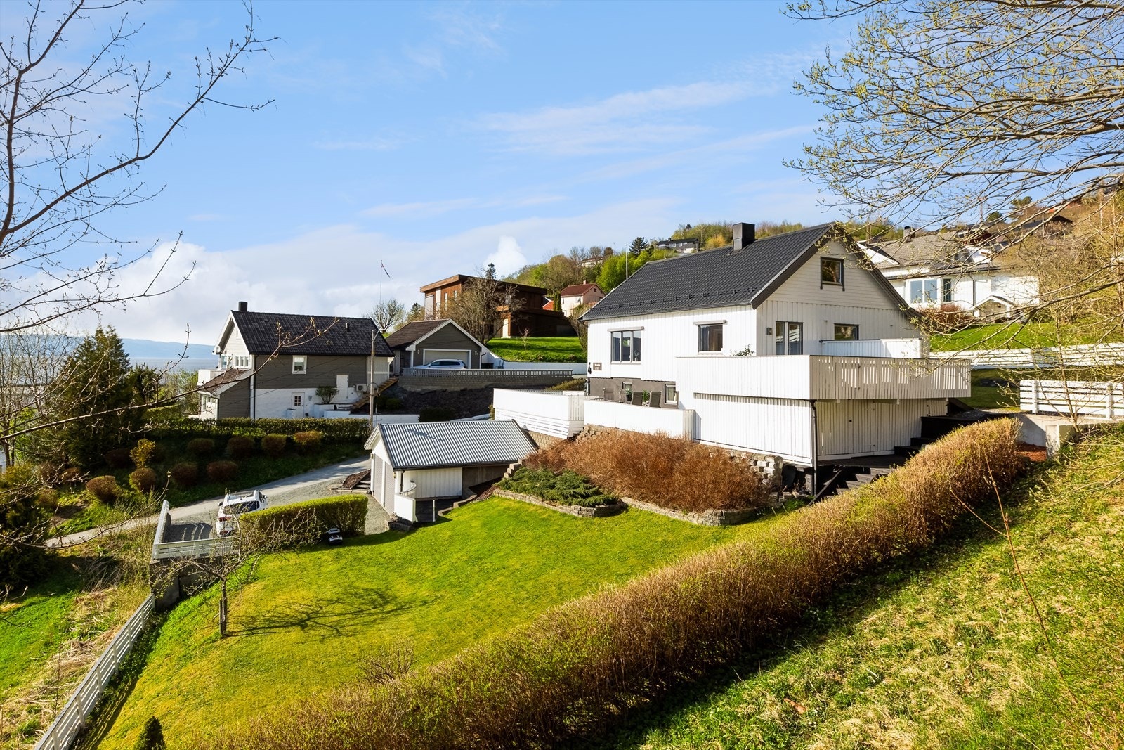 Boligen ligger høyt og fritt, på en stor og skrånende tomt med fin beplantning. Galleribilde