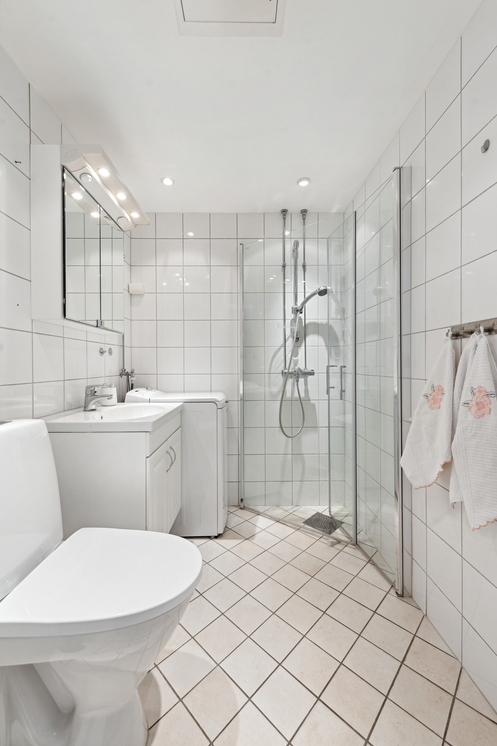 Pent flislagt baderom med varmekabler i gulv og senket himling med downlights. Galleribilde