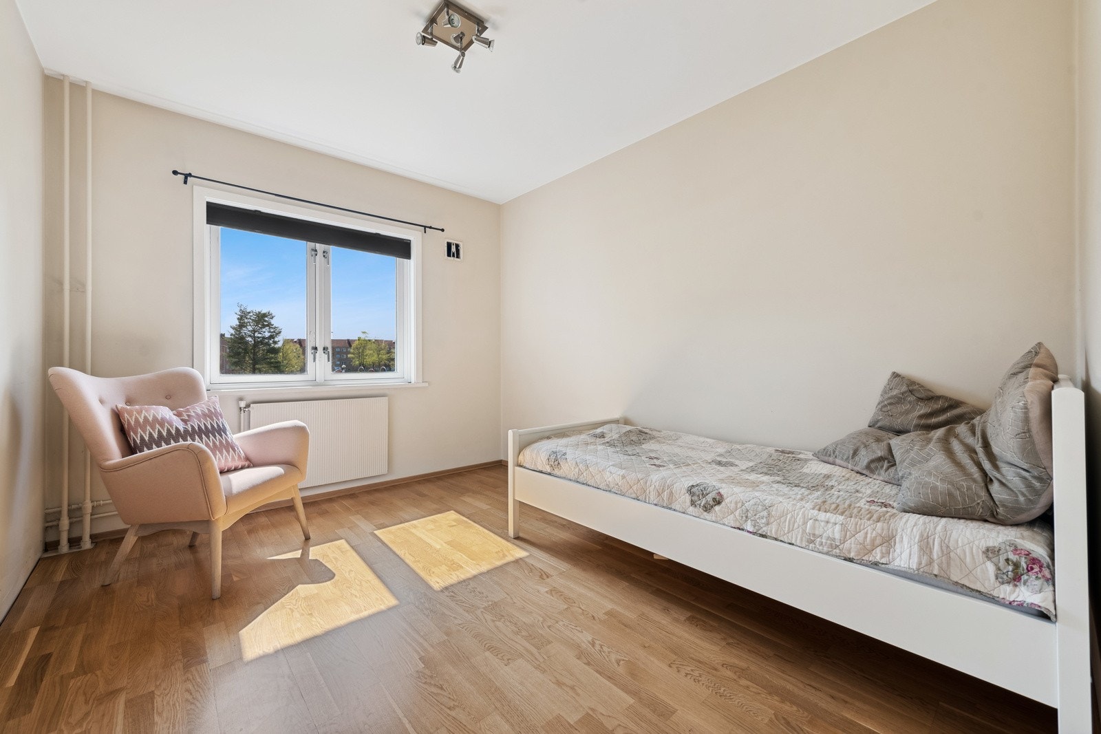 Soverommet vender ut mot store grøntarealer. Plissegardin i vindu som solskjerming. Galleribilde