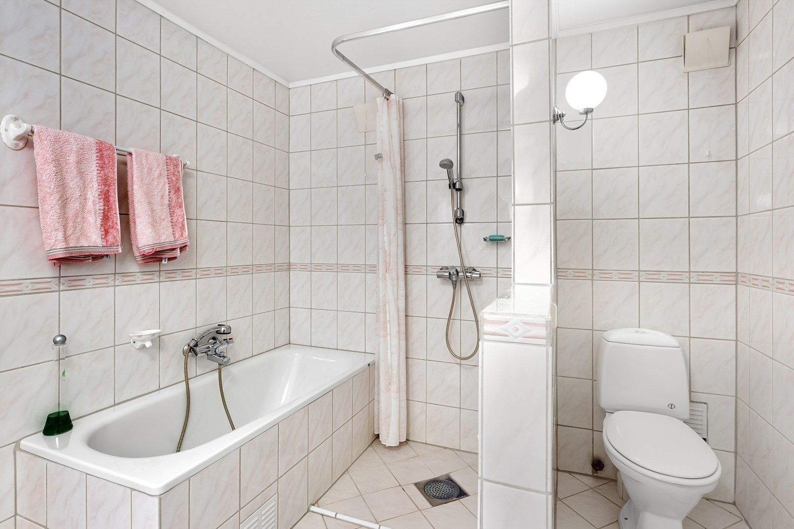 Her er både badekar og dusj. En 1/2 vegg skjermer toalettet. Galleribilde