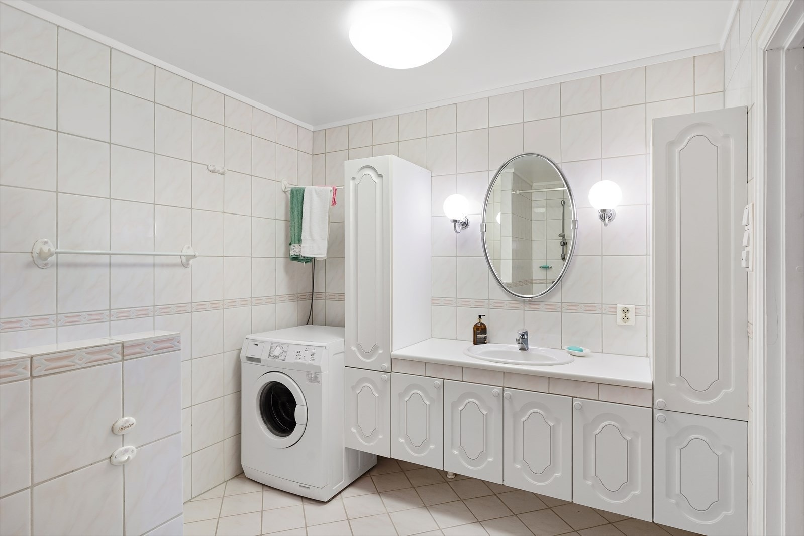 Bade er flislagt og er i lyse farger. Det ble pusset opp rundt 2001. Det er rikelig med baderomsinnredning hvor servanten er nedfelt i benkeplaten. Det er plass for vaskmaskin og tørketrommel. Varmekabler i gulvet. Galleribilde