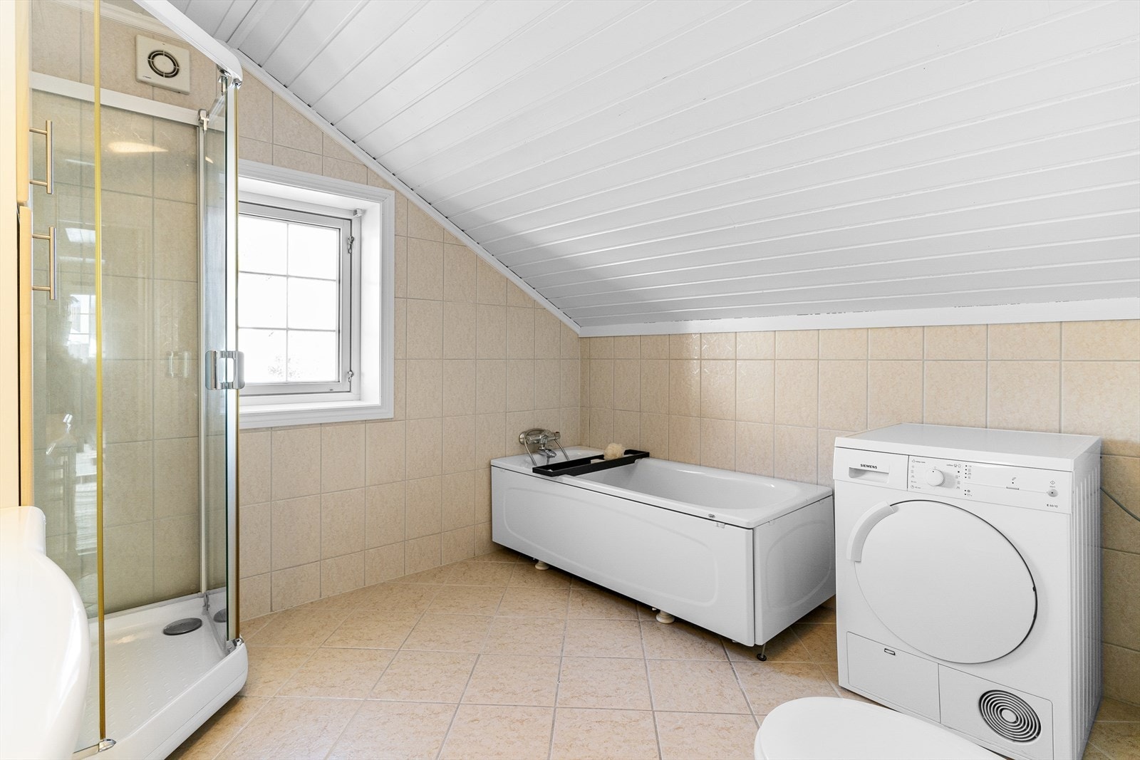 Badet i 2.etasje. Badet har innredning med nedfelt servant, veggmontert toalett, dusjkabinett og badekar. Veggene har fliser, taket har panel og gulvet er flislagt med elektriske varmekabler. Galleribilde