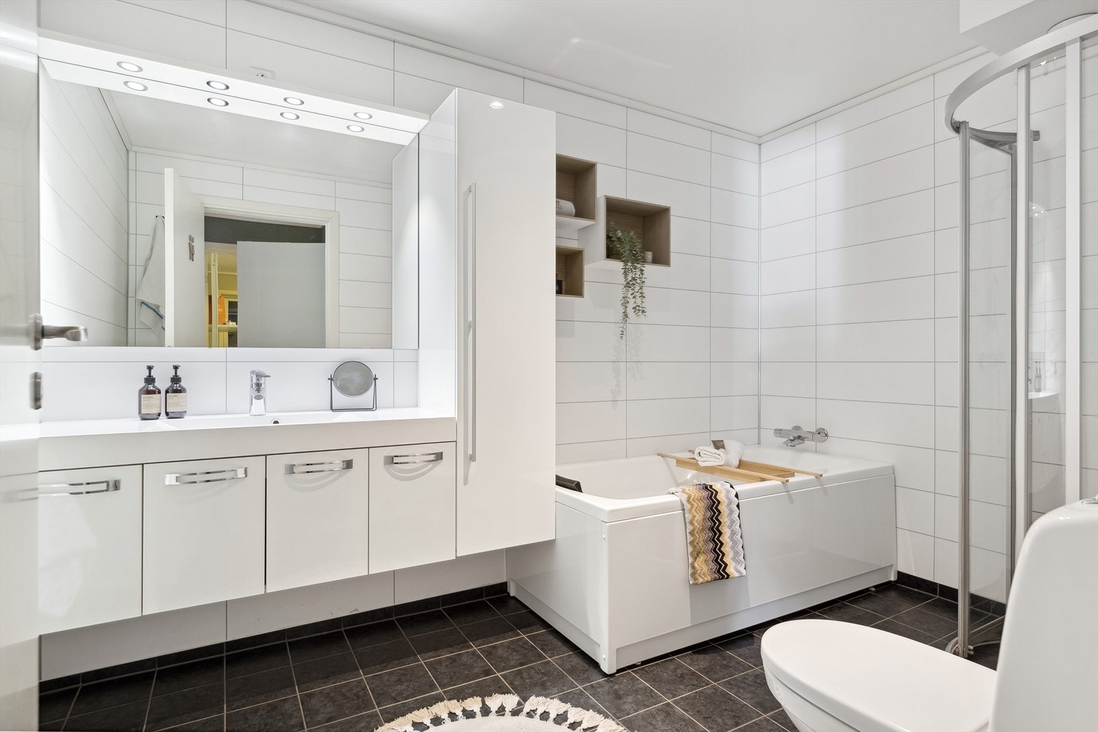 Badet er på romslige 7 kvm med flislagt gulv, lyse våtromsplater, gulvvarme og avtrekk via balansert ventilasjon. Galleribilde