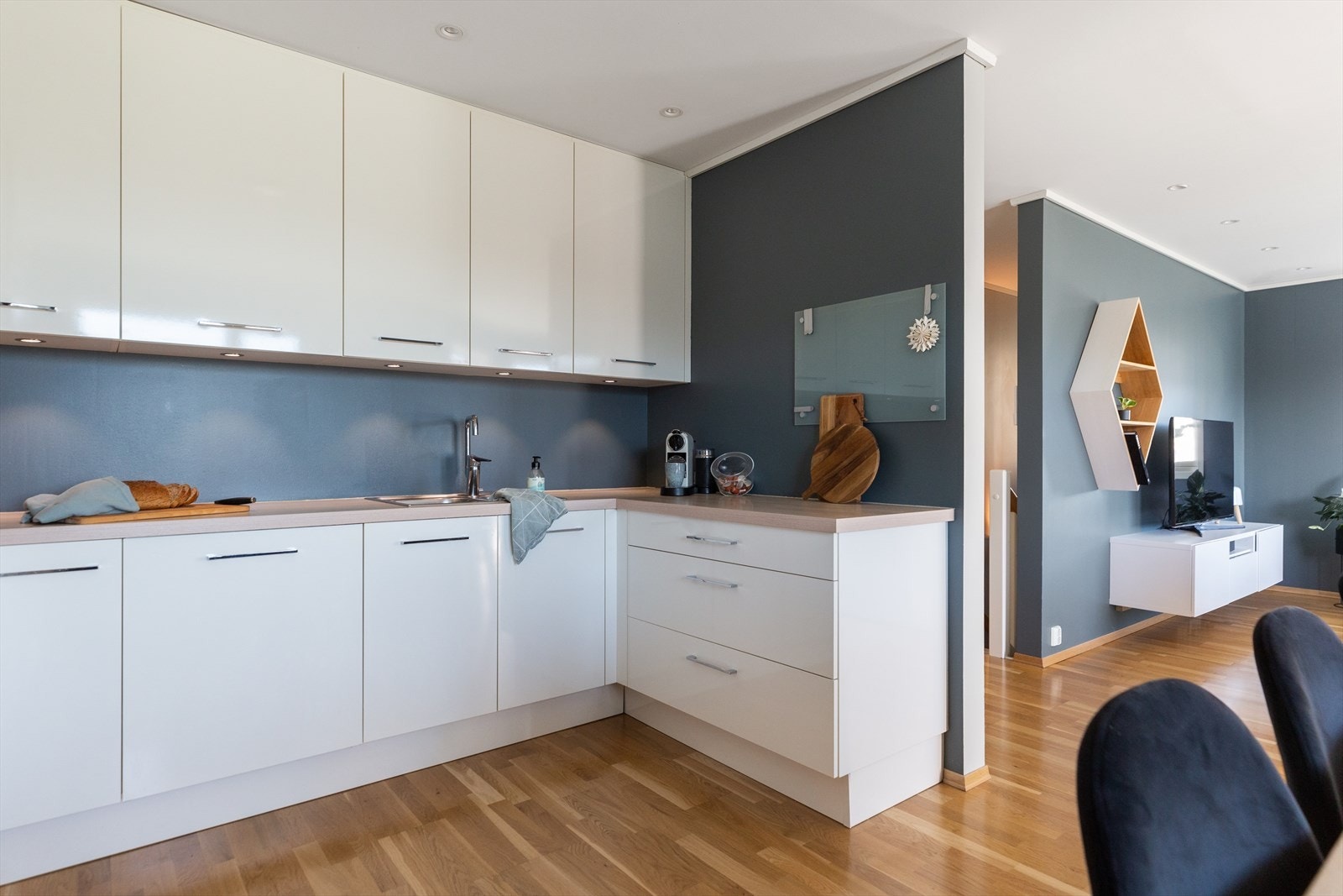 Stue og kjøkken har moderne stil med parkettgulv, downlights og mørk, harmonisk farge på veggene. Galleribilde