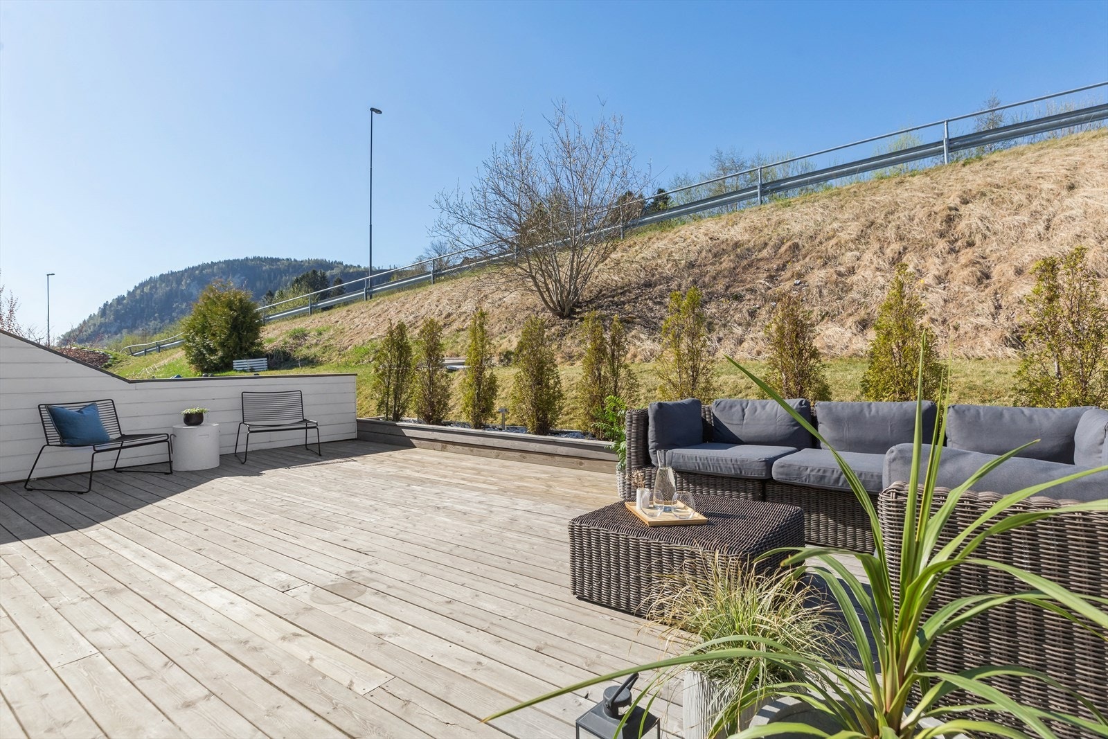 Terrassen har levegger på begge sider, og i front er det etablert en kasse med beplantninger. Galleribilde