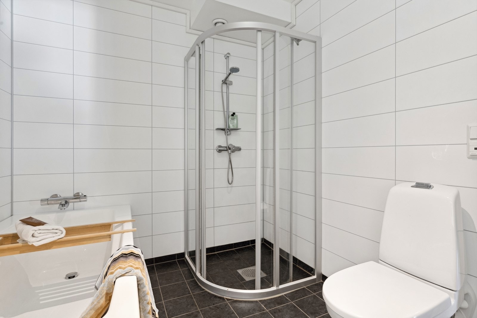 Badet har både en fin innredning, toalett, dusjhjørne og badekar. Galleribilde