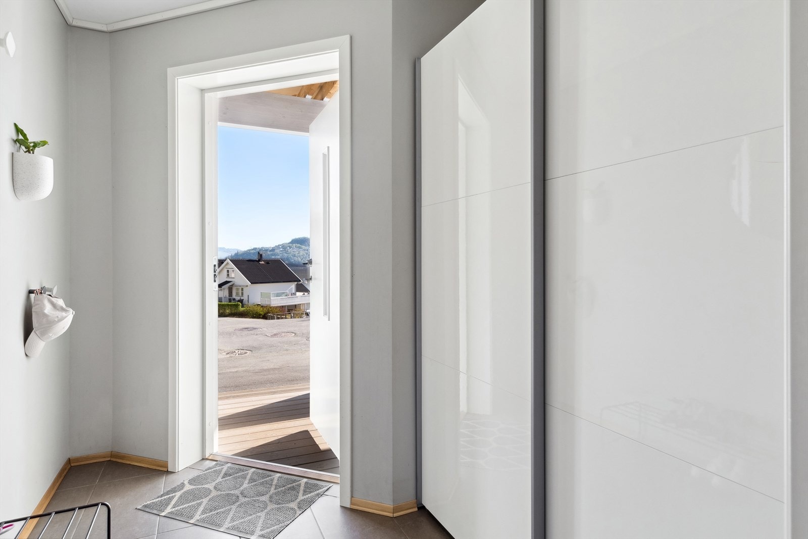 I gangen er det en romslig skyvedørsgarderobe med hvite fronter. Galleribilde