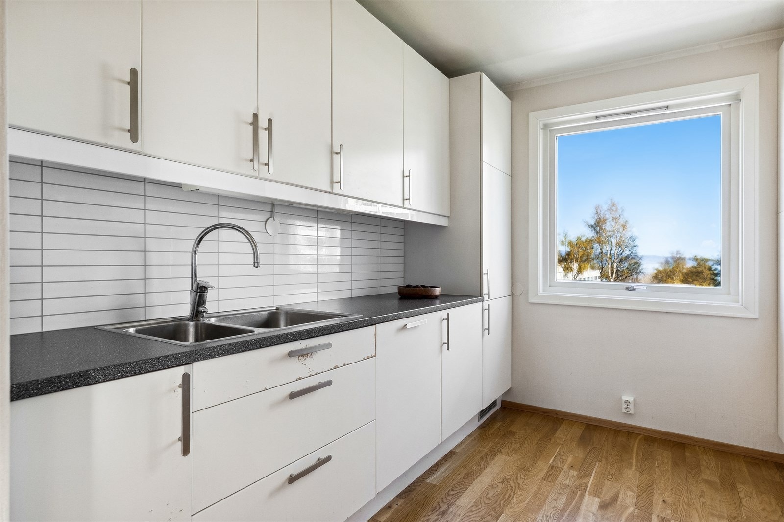 Innredningen har slette, stilrene fronter, benkeplater i laminat og integrerte hvitevarer. Galleribilde