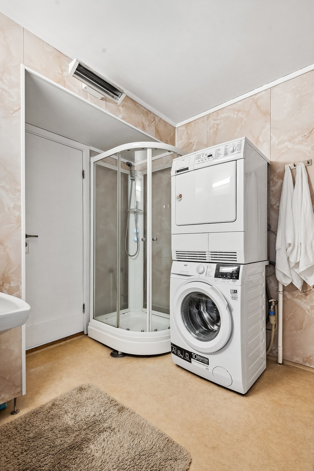 Badet er innredet med servantskap, dusjkabinett og opplegg for vaskemaskin. Det er i tillegg separat toalettrom. Galleribilde