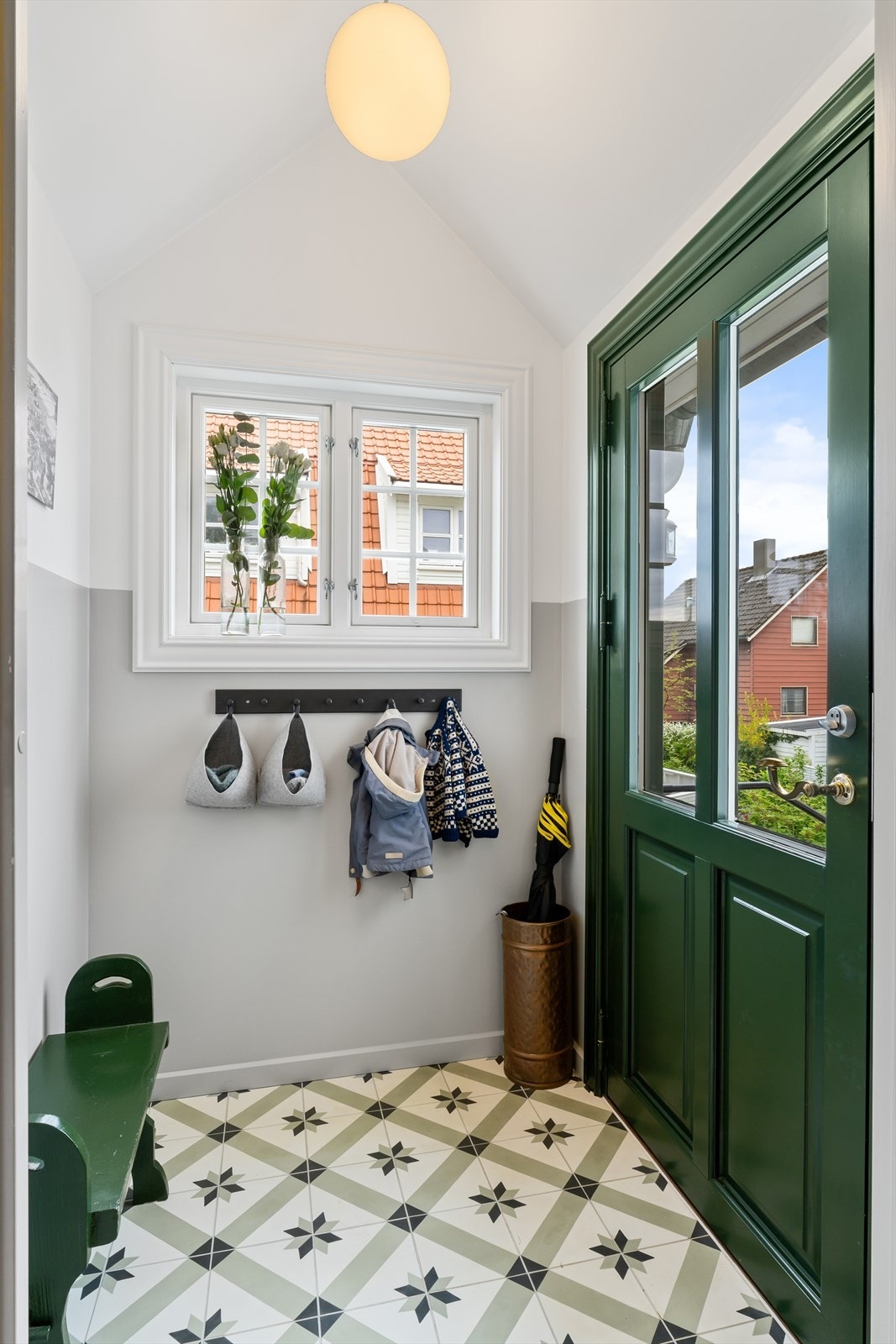 Koselig entré med flotte detaljer som grønn dør og mønstret gulv Galleribilde