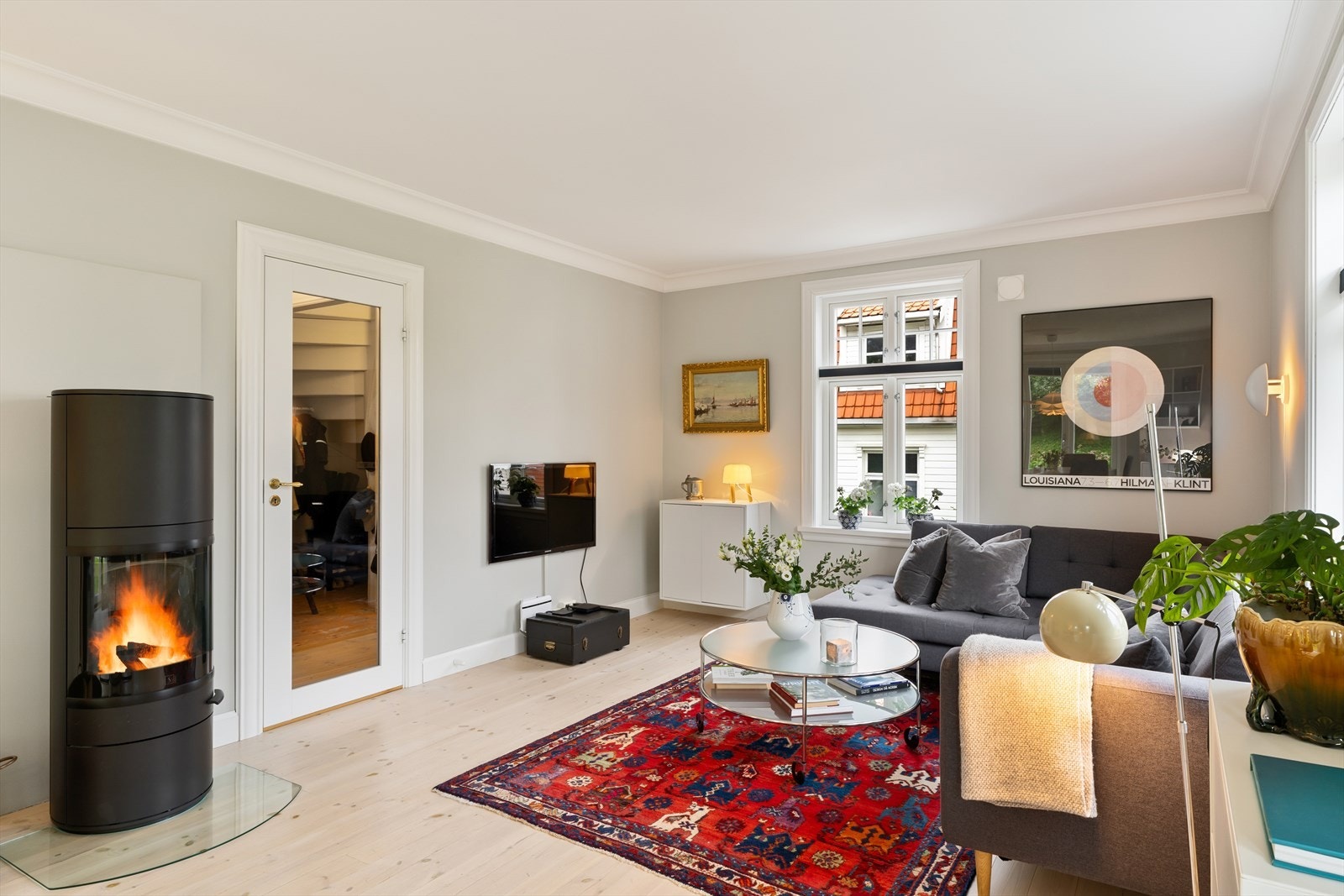 Lys og innbydende stue med moderne peis og klassiske designelementer Galleribilde