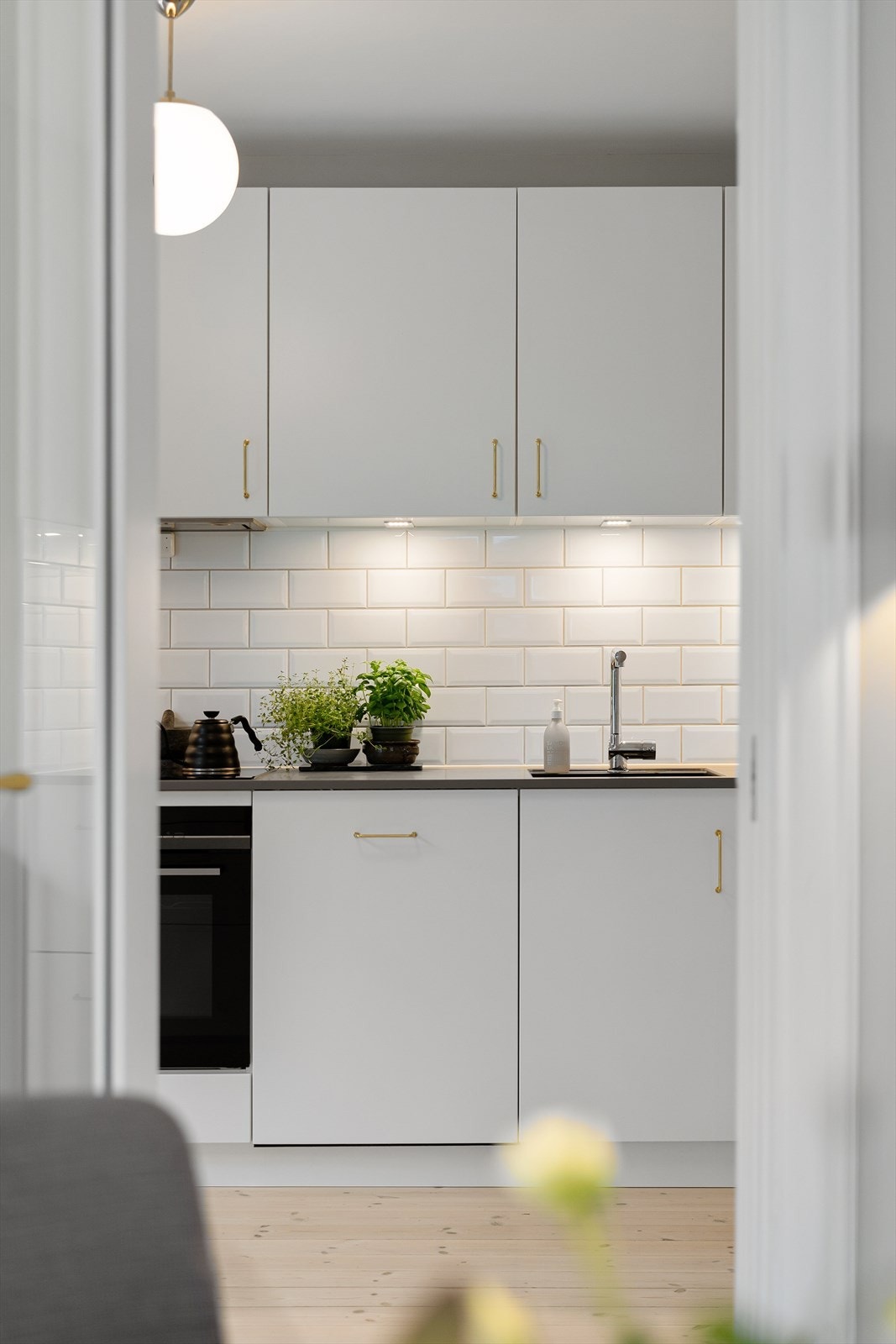 Moderne og stilrent kjøkken med integrerte hvitevarer og elegante gullfargede detaljer Galleribilde