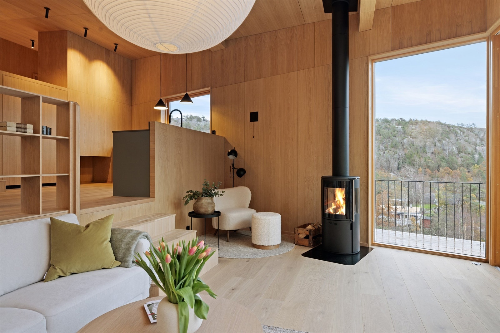 Stue med moderne peisovn og store vindusflater Galleribilde