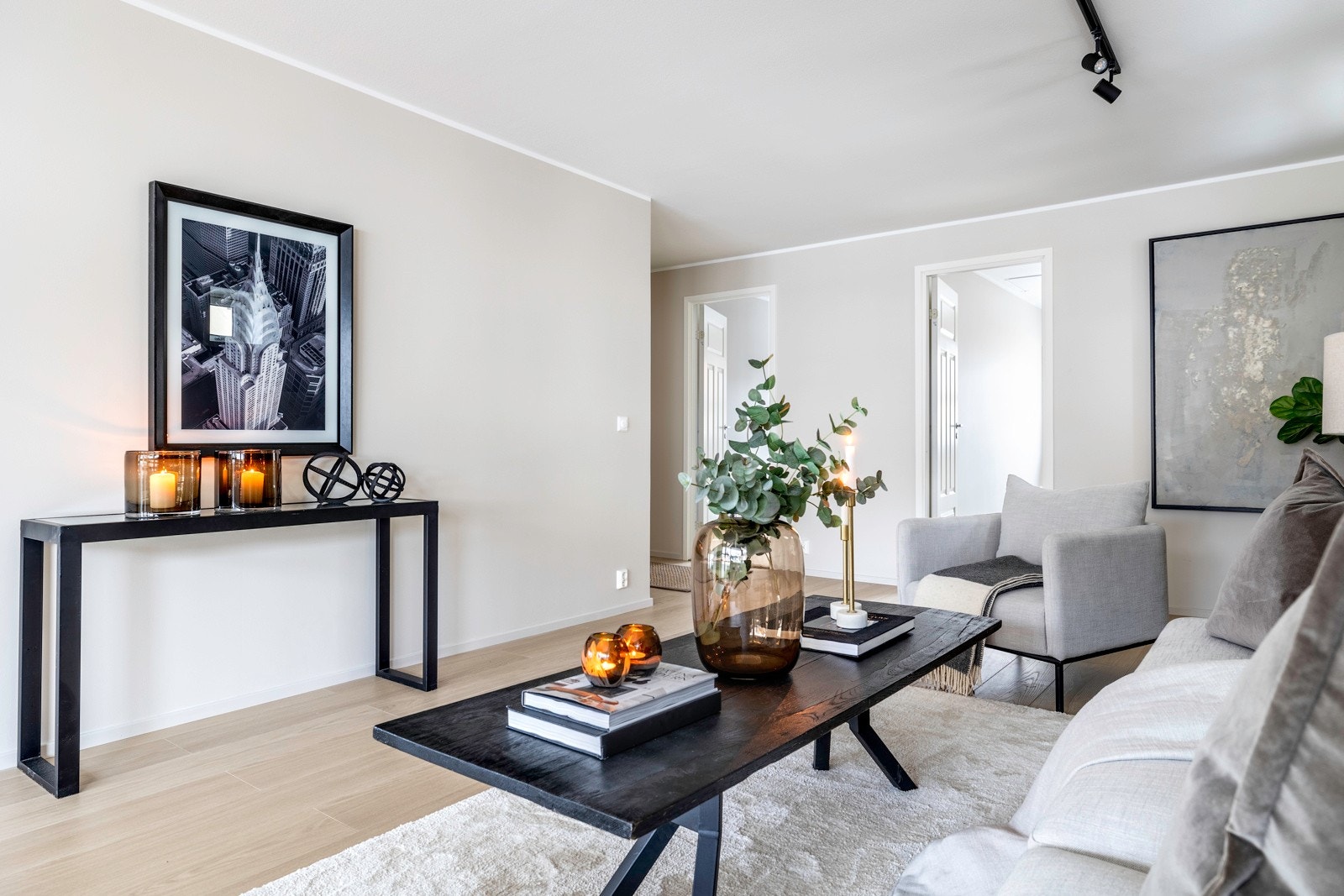 Over sofaplassen er det montert en sort spotskinne. Galleribilde