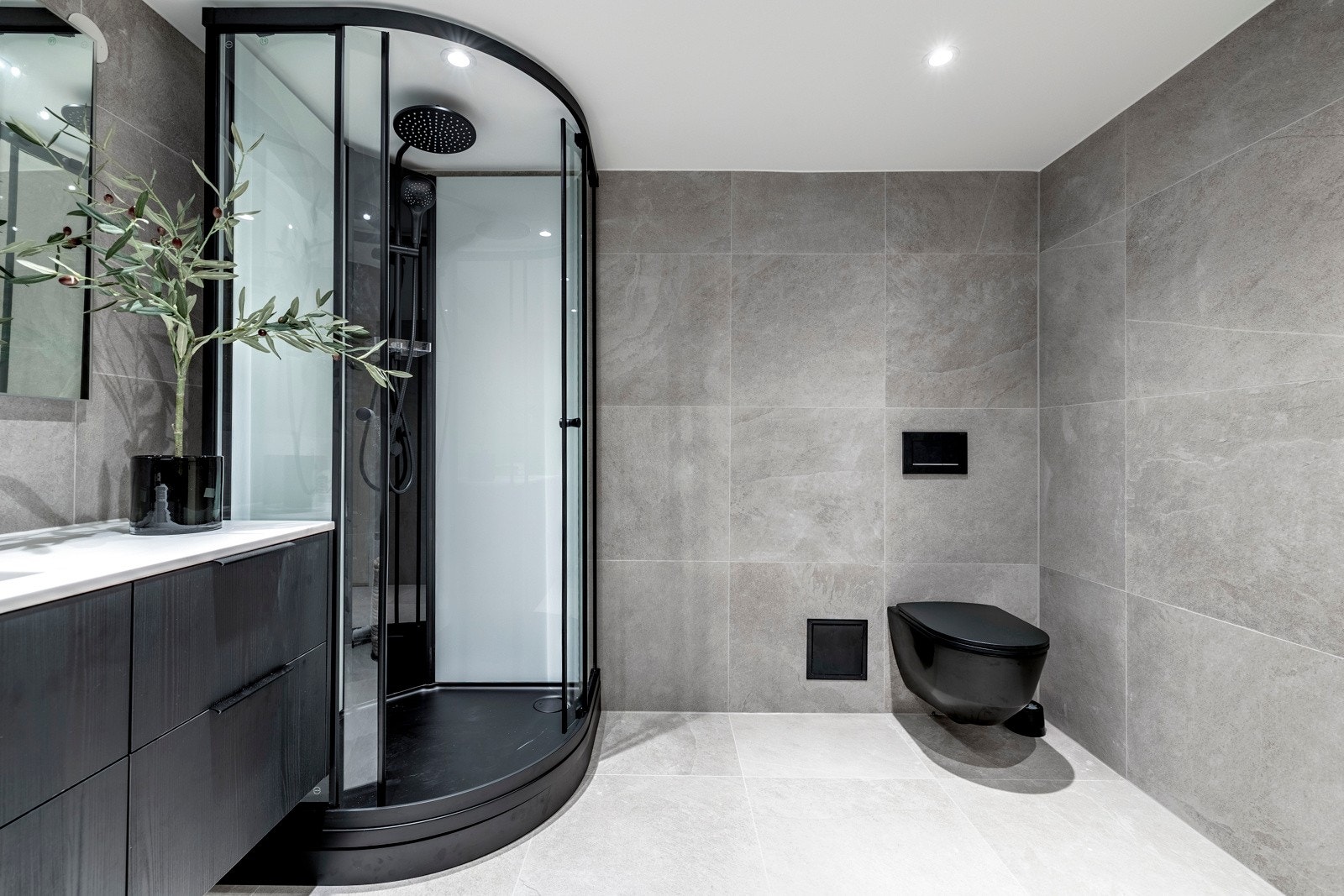 Toalettet, servantkraner, armaturer og omramming på dusjkabinettet er holdt i sort, som både er trendy og elegant. Galleribilde