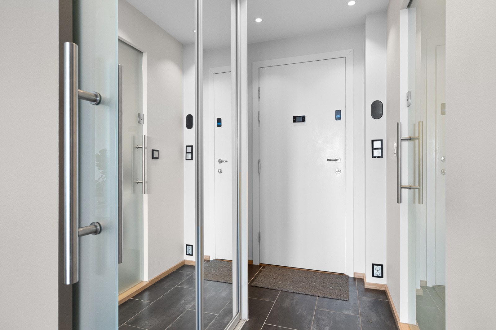 Fin entré/gang med god plass til oppbevaring av sko og yttertøy i praktisk skyvedørsgarderobe med speilfronter. Galleribilde