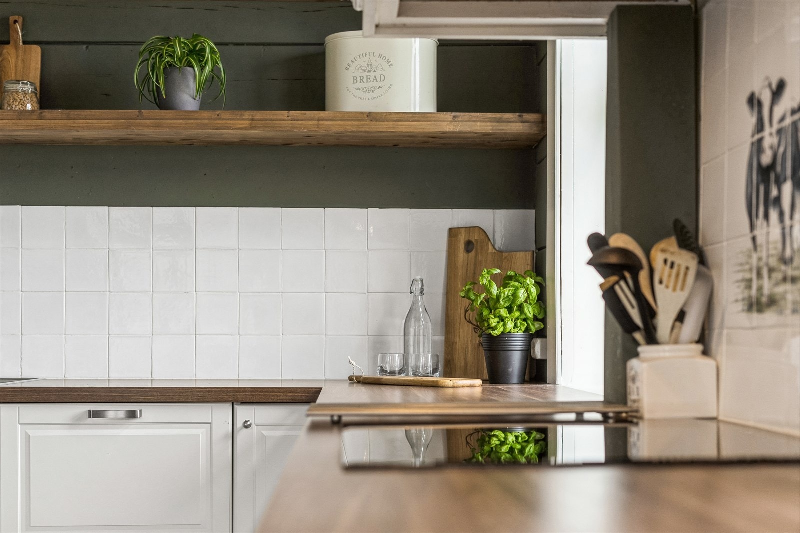 Eit kjøkken som inspirerer til matlaging og baking. Med flisar mellom over- og underskap blir det enkelt å halde reint. Galleribilde