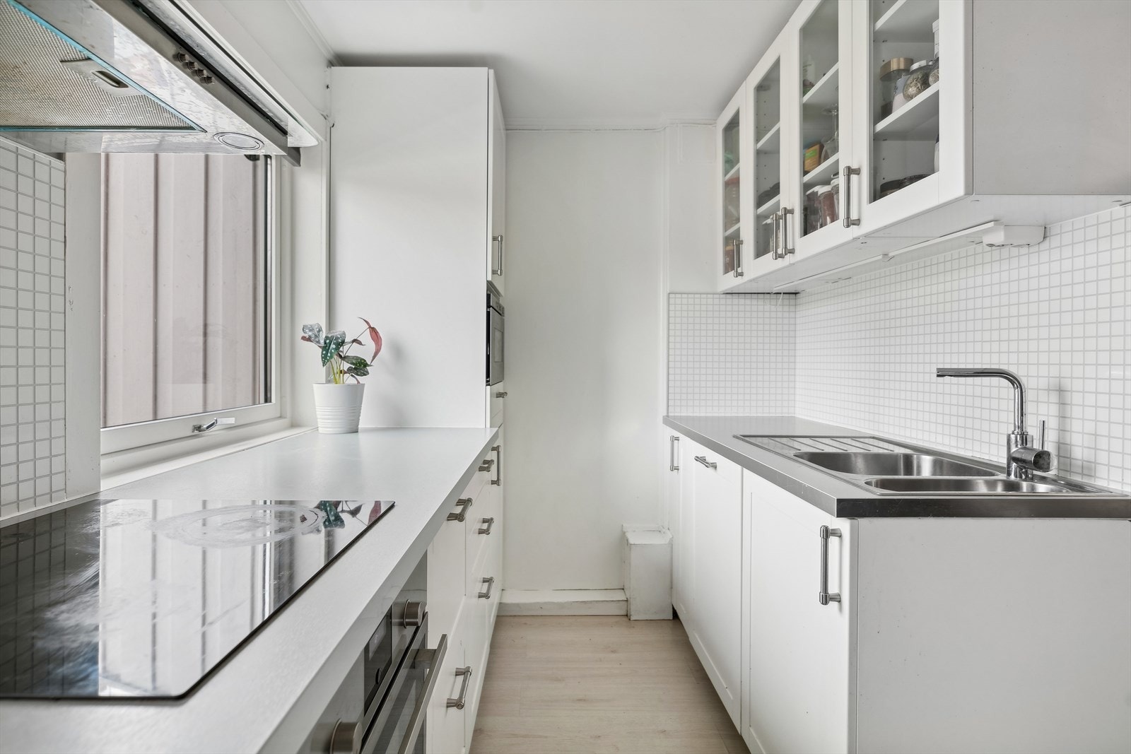 Kjøkken har en fin størrelse og har innredning med hvite profilerte fronter og laminat benkeplate med nedfelt kum og ettgreps blandebatteri. Galleribilde